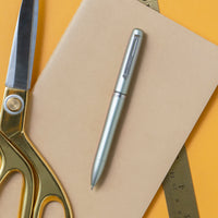 uniball™ JETSTREAM PRIME, 0.5mm Ballpoint Pen, Matte Metal Barrel, in use with notebook and office supplies, 352245000